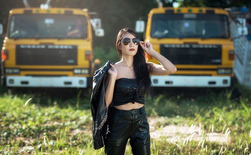 Woman with sunglasses and trucks in background